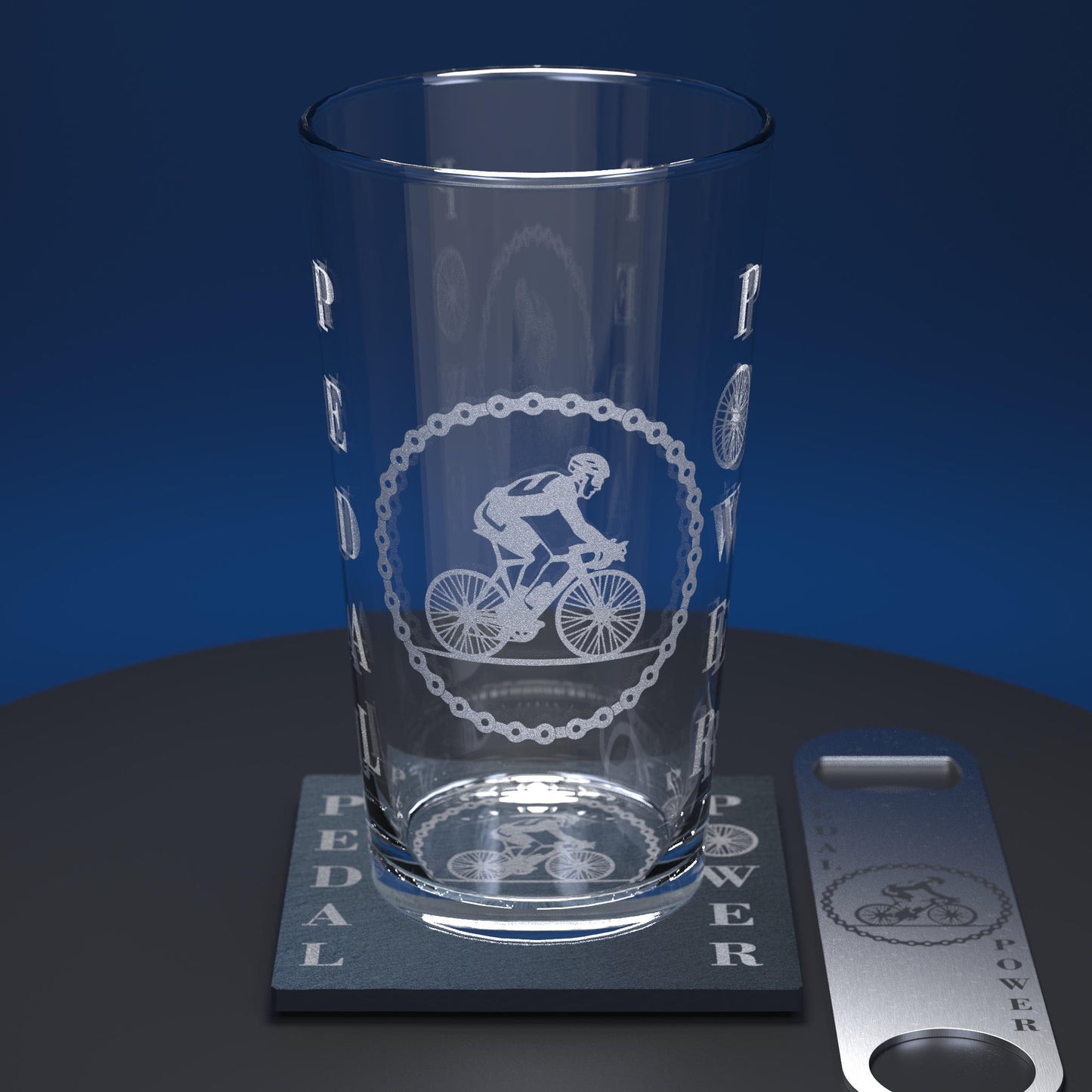 Pint glass set consisting of engraved glass with image of cyclist and Pedal Power text, includes matching slate coaster and stainless steel bottle opener