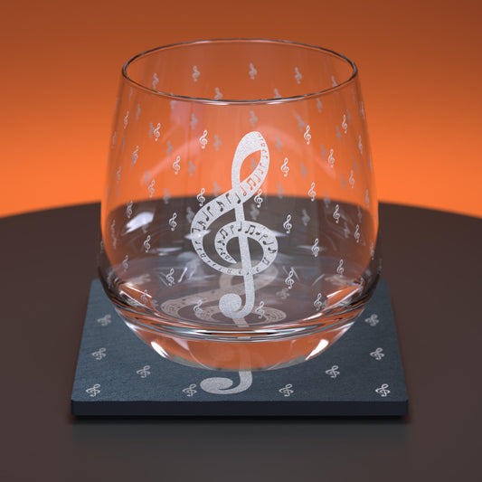 Glass whiskey tumbler with slate coaster engraved with treble clefs