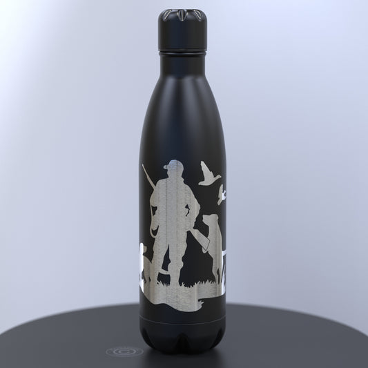 A matte black insulated water bottle with a lid, featuring a silver etched graphic of a duck hunter silhouette with ducks and a dog 